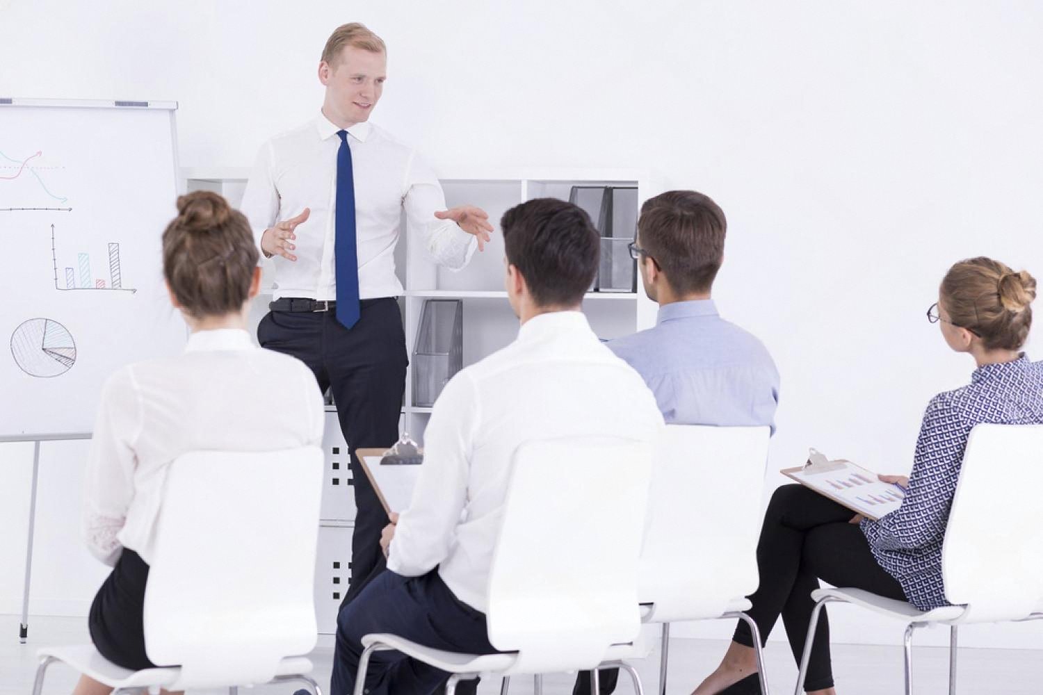 Instructor teaching a small group of adult students at a vocational training center classroom